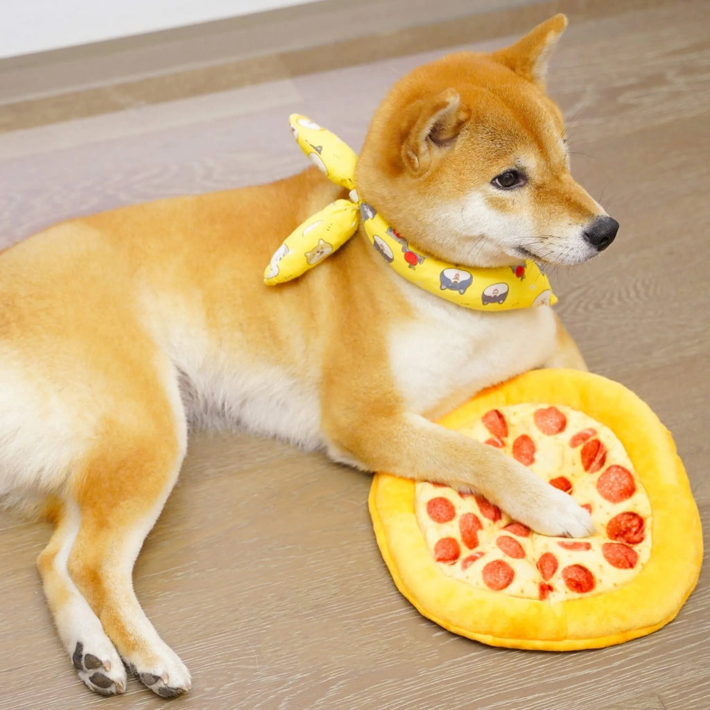 Yellow pizza slice shaped soft plush dog chew toy with squeaker on a white background.