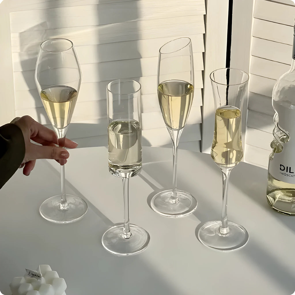 Six French crystal champagne glasses in various designs on dining table
