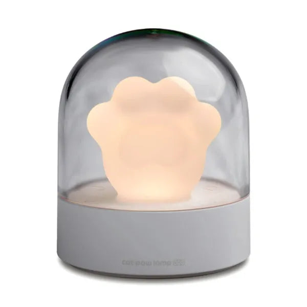 Grey cat paw shaped USB rechargeable night light with music box on a desk.