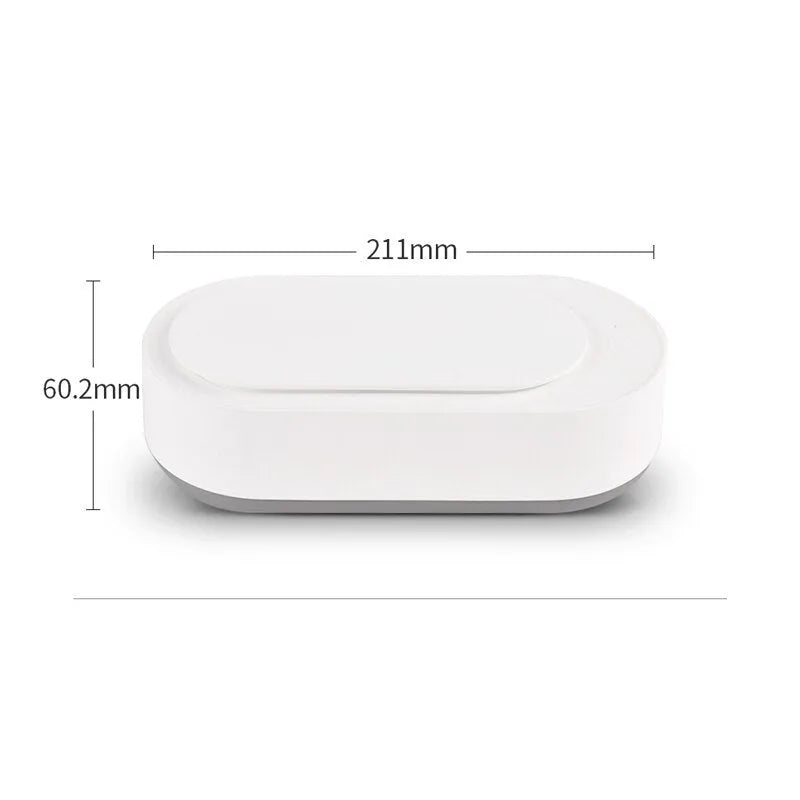 White portable ultrasonic cleaner with stainless steel tank and a single control button.