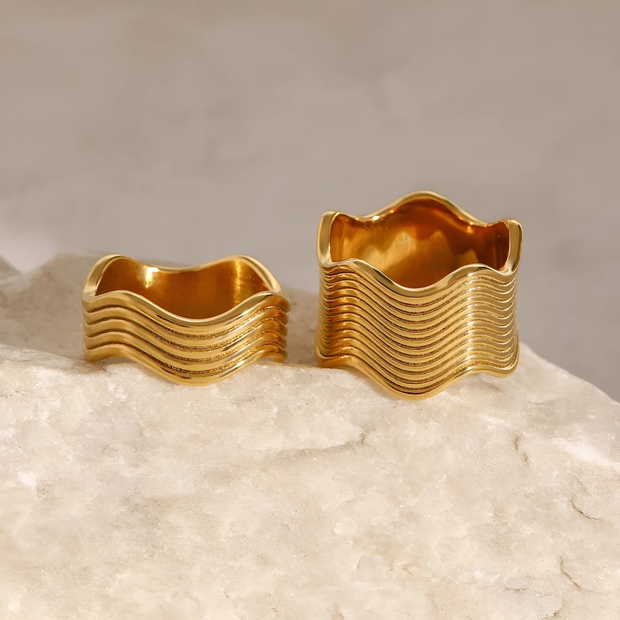 Stainless steel wide band ring with an embossed geometric wave pattern, shown in an electroplated colour.