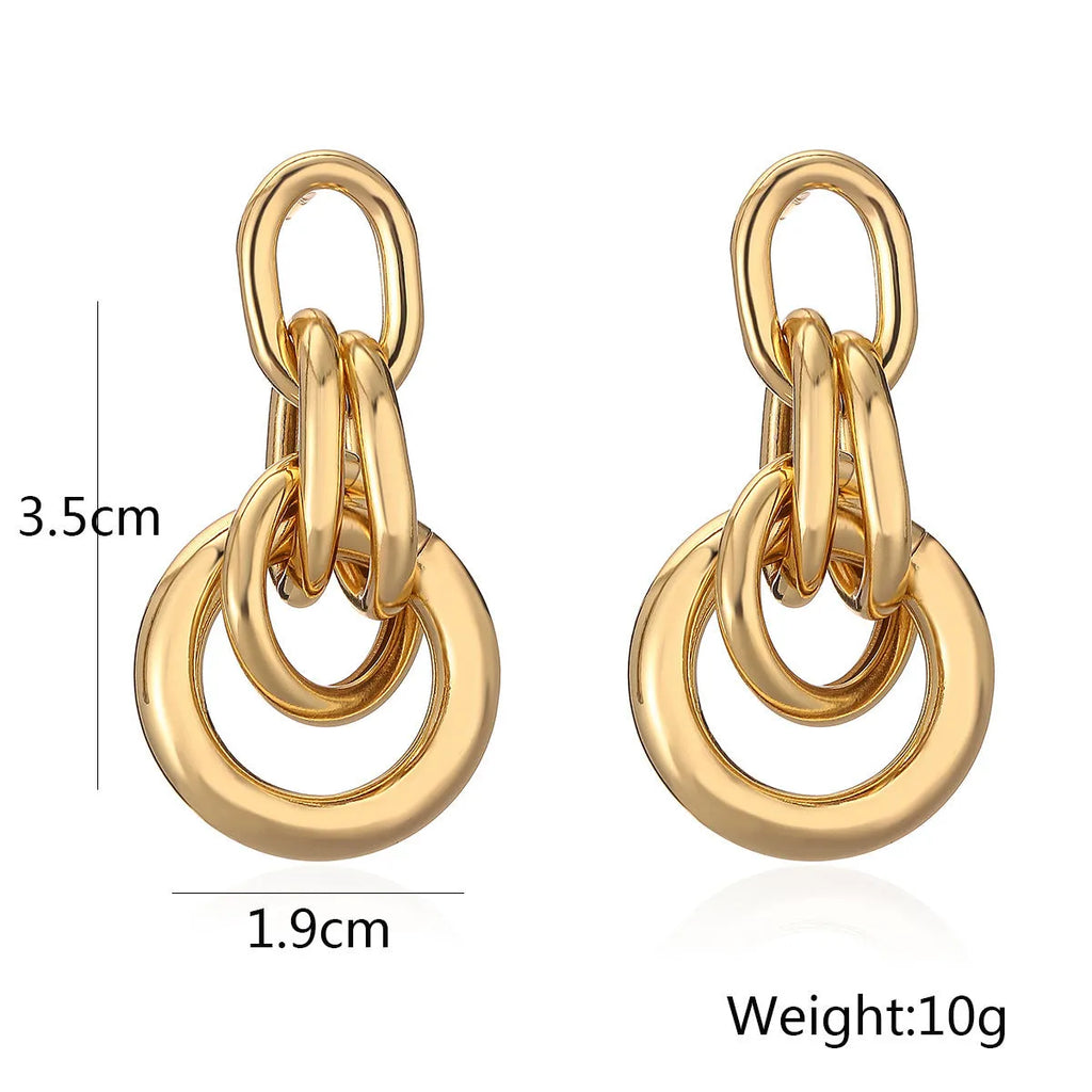 Geometric gold drop earrings with an irregular shape on a copper base.