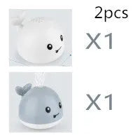 Whale-shaped baby bath toy with automatic water spray and colourful lights floating in water.