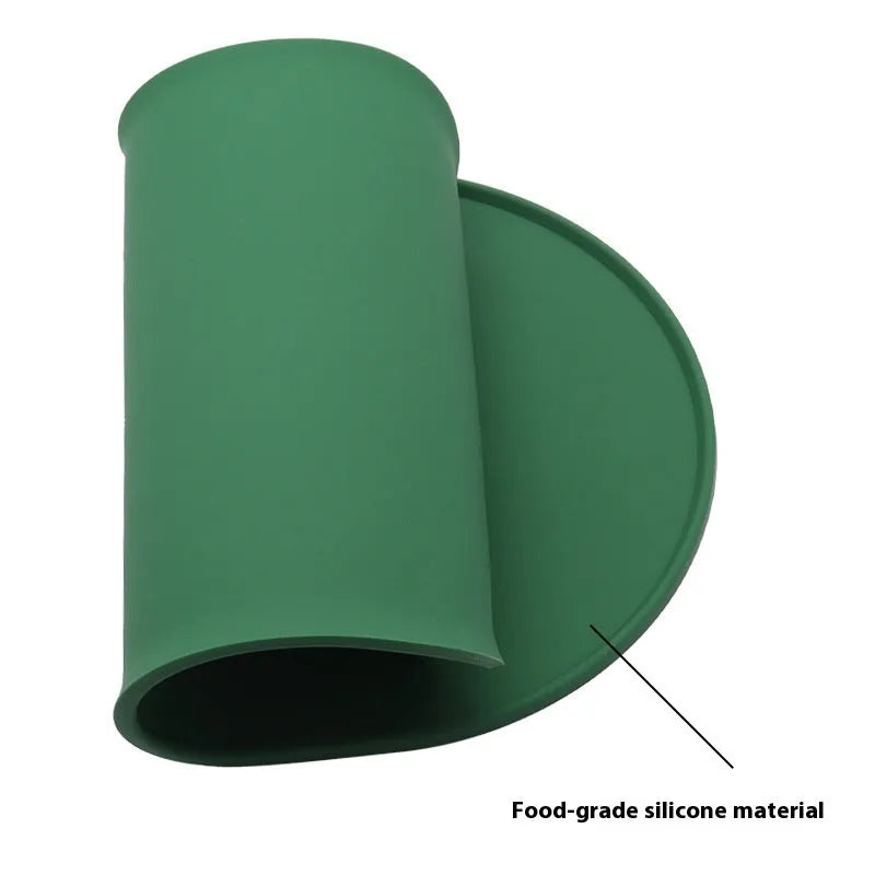 Silicone cat feeding placemat in beige colour, shown under food and water bowls on a kitchen floor.