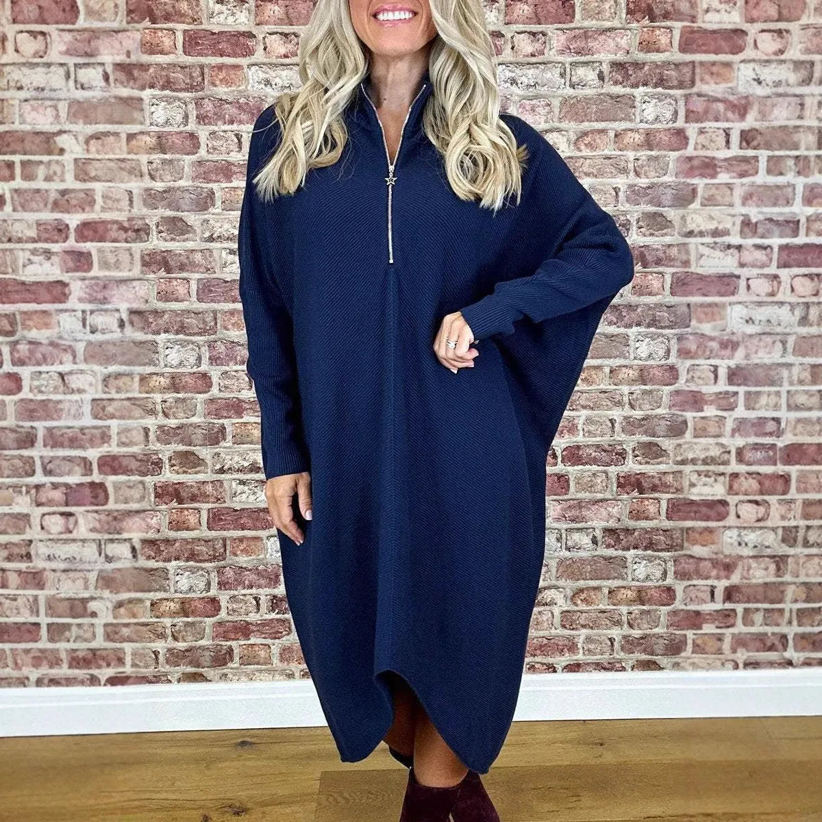 Women's solid colour loose knitted dress with raglan sleeves and a front zip closure.