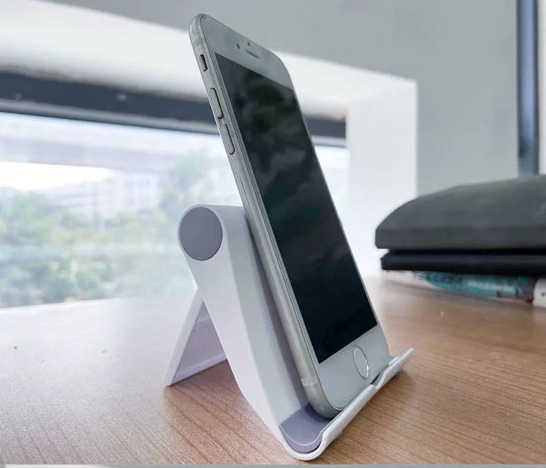 Black PE folding phone and tablet stand with soft rubber backing, shown at an adjustable angle.