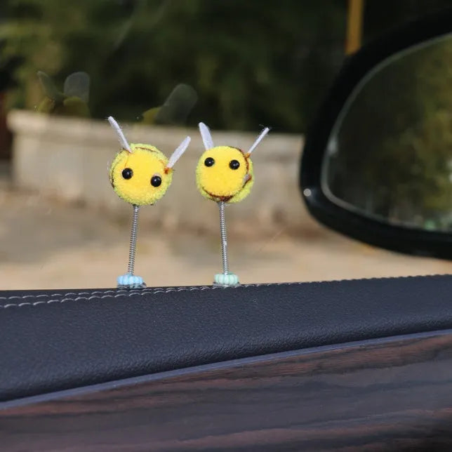 Small yellow and black fur ball bee car ornament with adhesive backing.