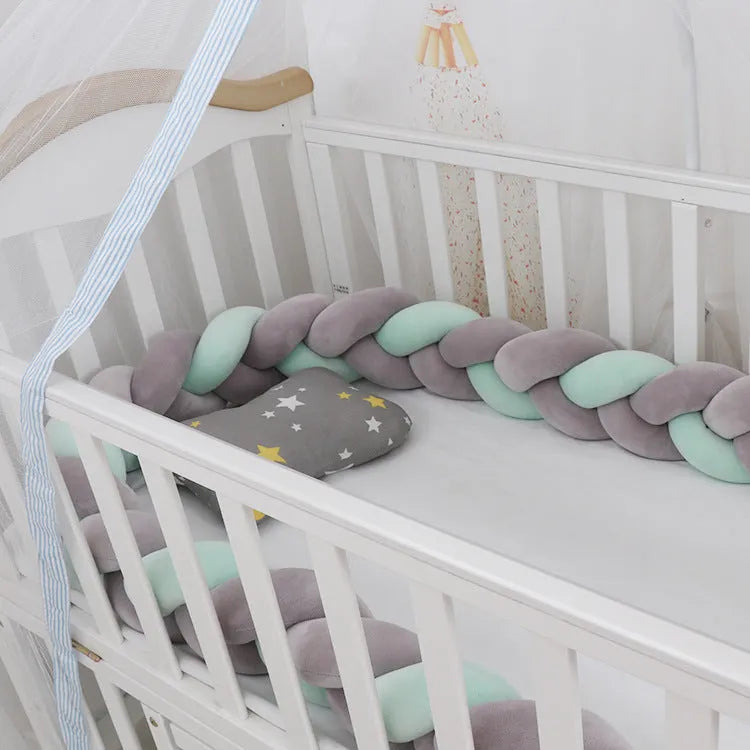 Braided knot pillow cushion bumper for infant crib in spandex velvet, shown in a light colour.