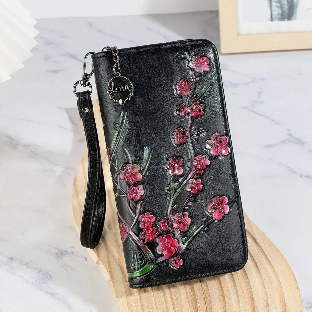 Embossed floral handbag with hand-painted details and a brass zipper in a retro style.