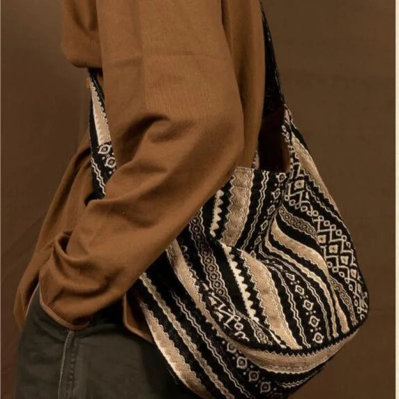 Retro striped corduroy messenger bag with jacquard detail and an adjustable plaid shoulder strap.
