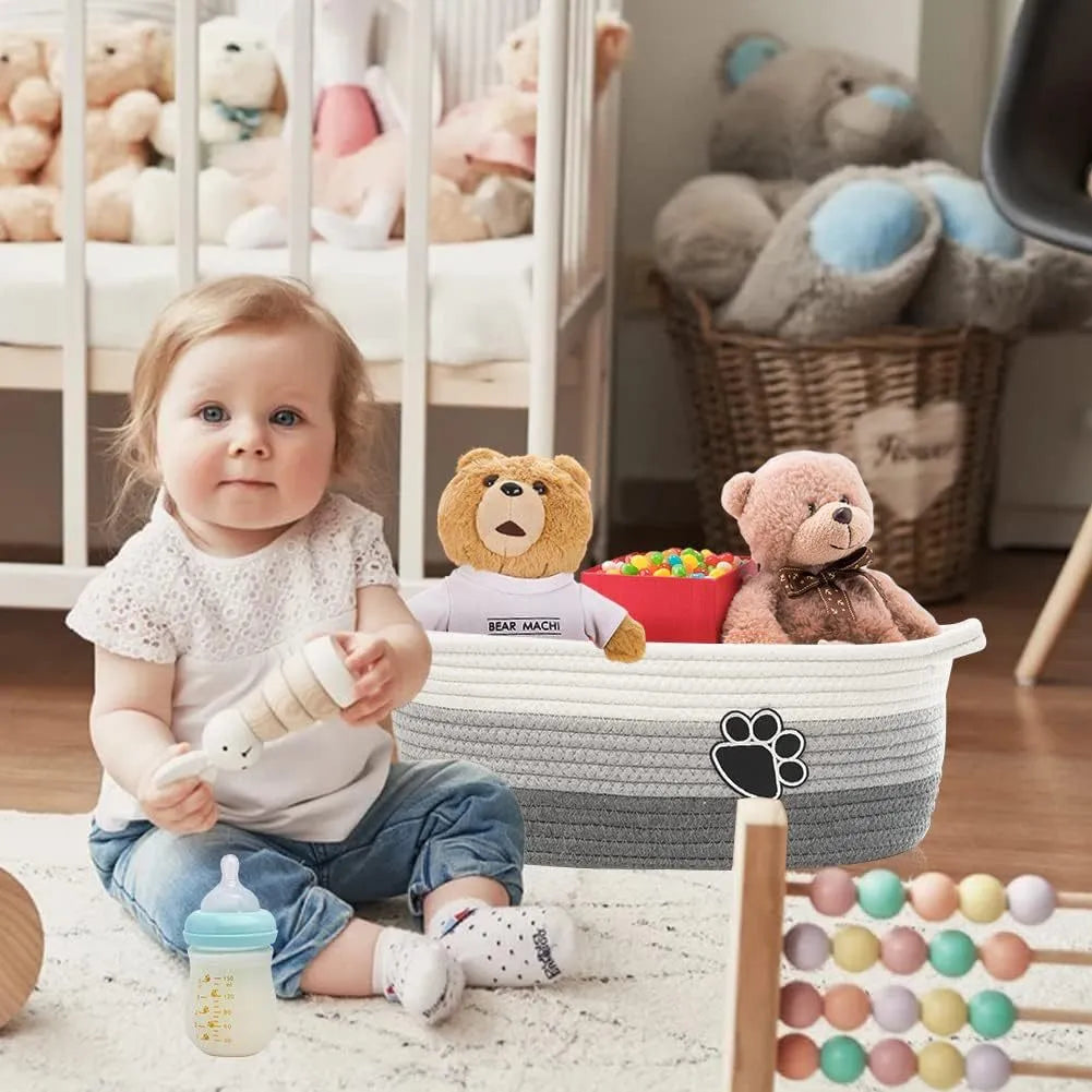 Light beige handmade cotton rope storage basket with handle on a wooden surface.