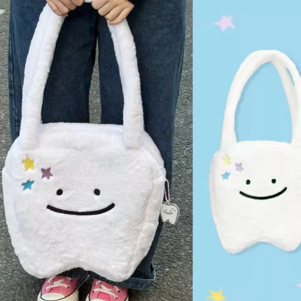 White plush large tooth shoulder tote bag with crossbody strap and zip closure.