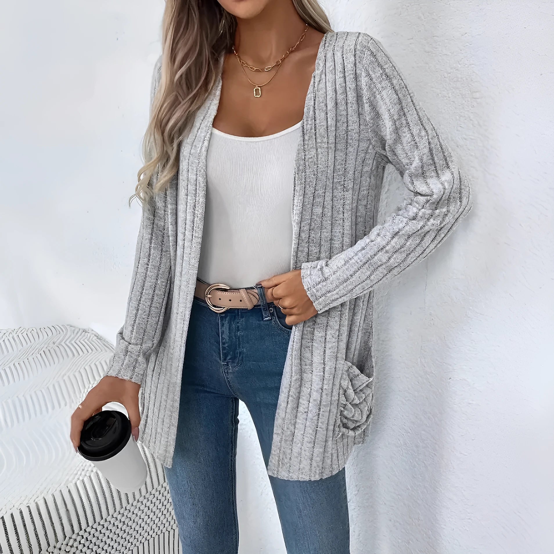 A person wearing a solid grey loose fit long sleeve cardigan with a chest pocket.