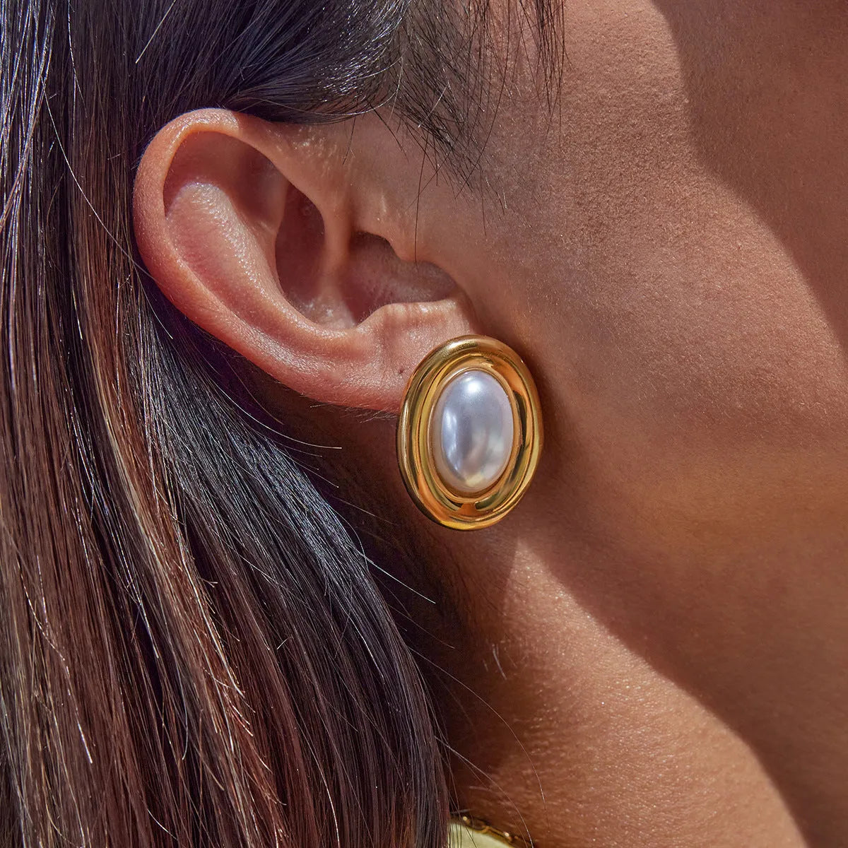A pair of stainless steel stud earrings with a vintage-style faux pearl centre in colour JDE0305051.