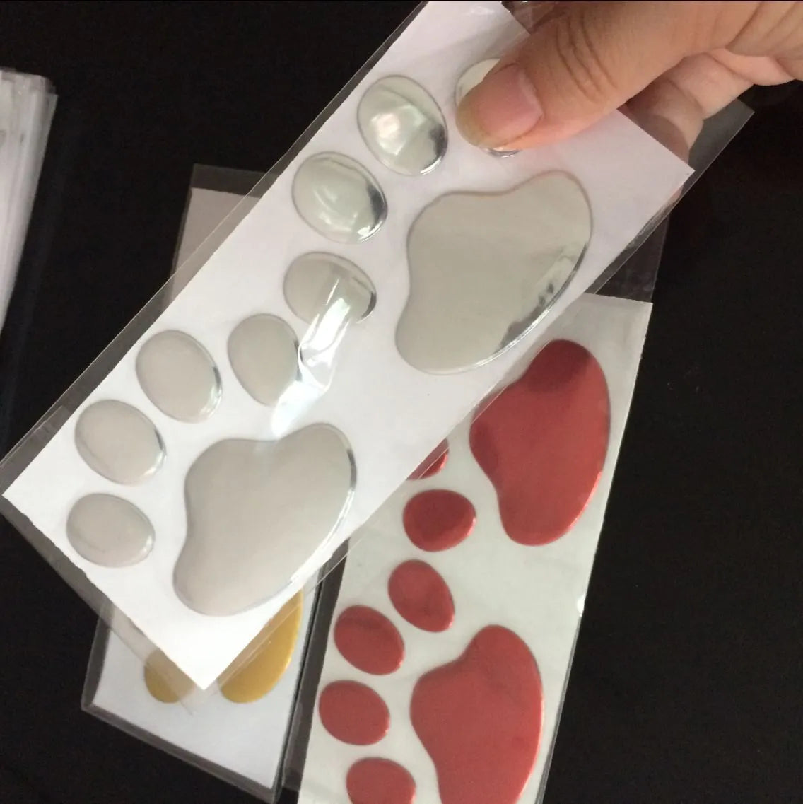 PVC car sticker with hand-shaped brush dog footprints design on a car bumper.