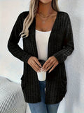 A person wearing a solid grey loose fit long sleeve cardigan with a chest pocket.