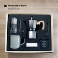 Six-piece manual grinding machine set in beige and black with moka pot, cup, bean jar, and accessories