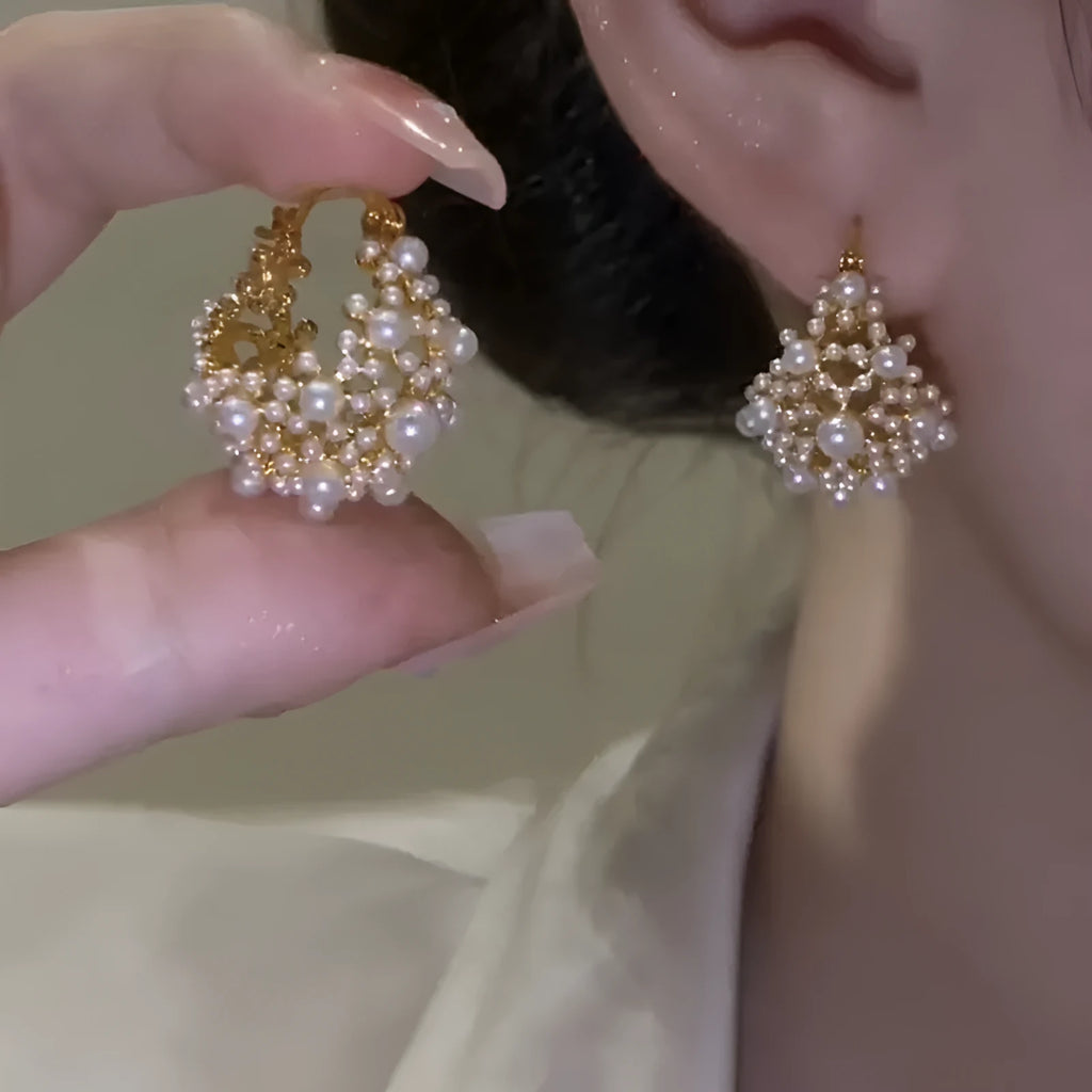 Gold tone copper flower basket earrings with small rice-shaped beads and a central pearl inlay.
