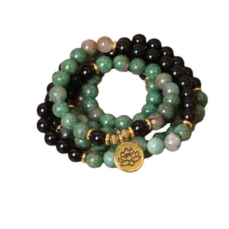 Green and black elastic beaded long bracelet with alloy construction shown on wrist