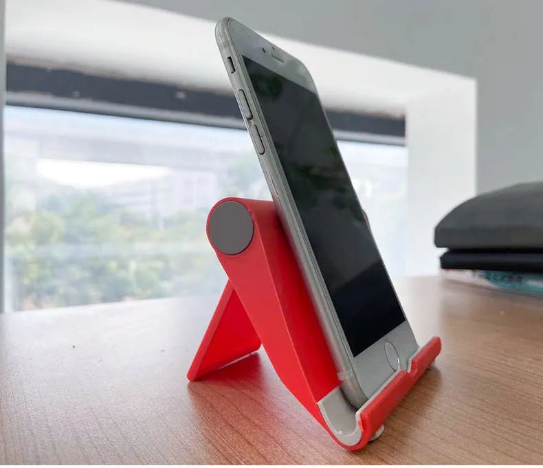 Black PE folding phone and tablet stand with soft rubber backing, shown at an adjustable angle.