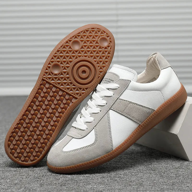 Men's low top white retro sneakers with round toe and flat rubber sole on a plain background