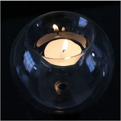 Handmade round hollow glass candle holder in clear glass on wooden surface