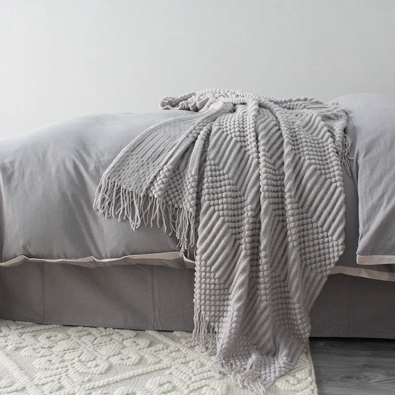 Small grey polyester nap blanket laid flat showing its size.