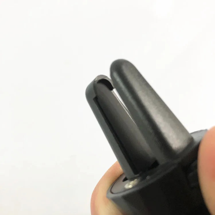 Black car phone holder clipped onto vehicle air vent with phone securely mounted