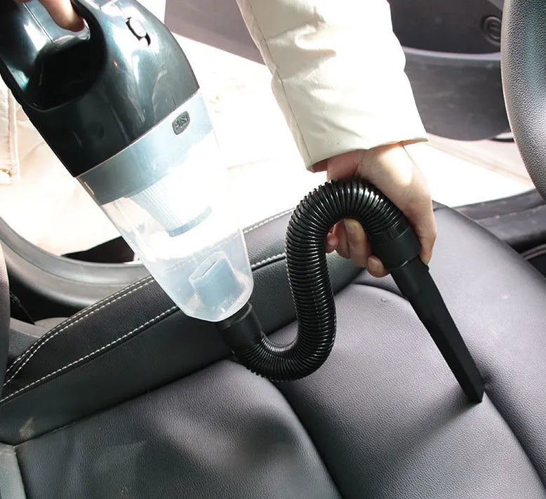 Portable 12V car vacuum cleaner in orange colour with nozzle attachments for automotive interior cleaning