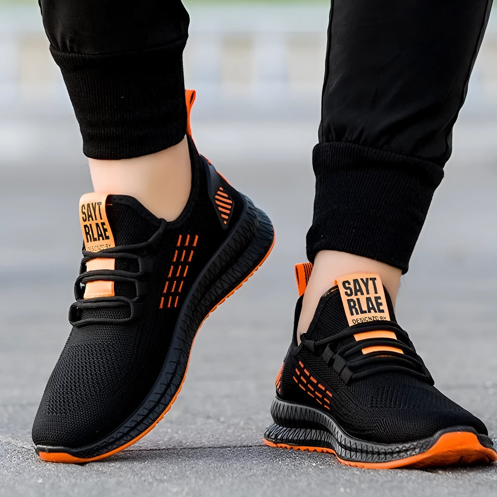 Men's black casual sports shoes with flying three bars stripe pattern and cross strap details on a white background.