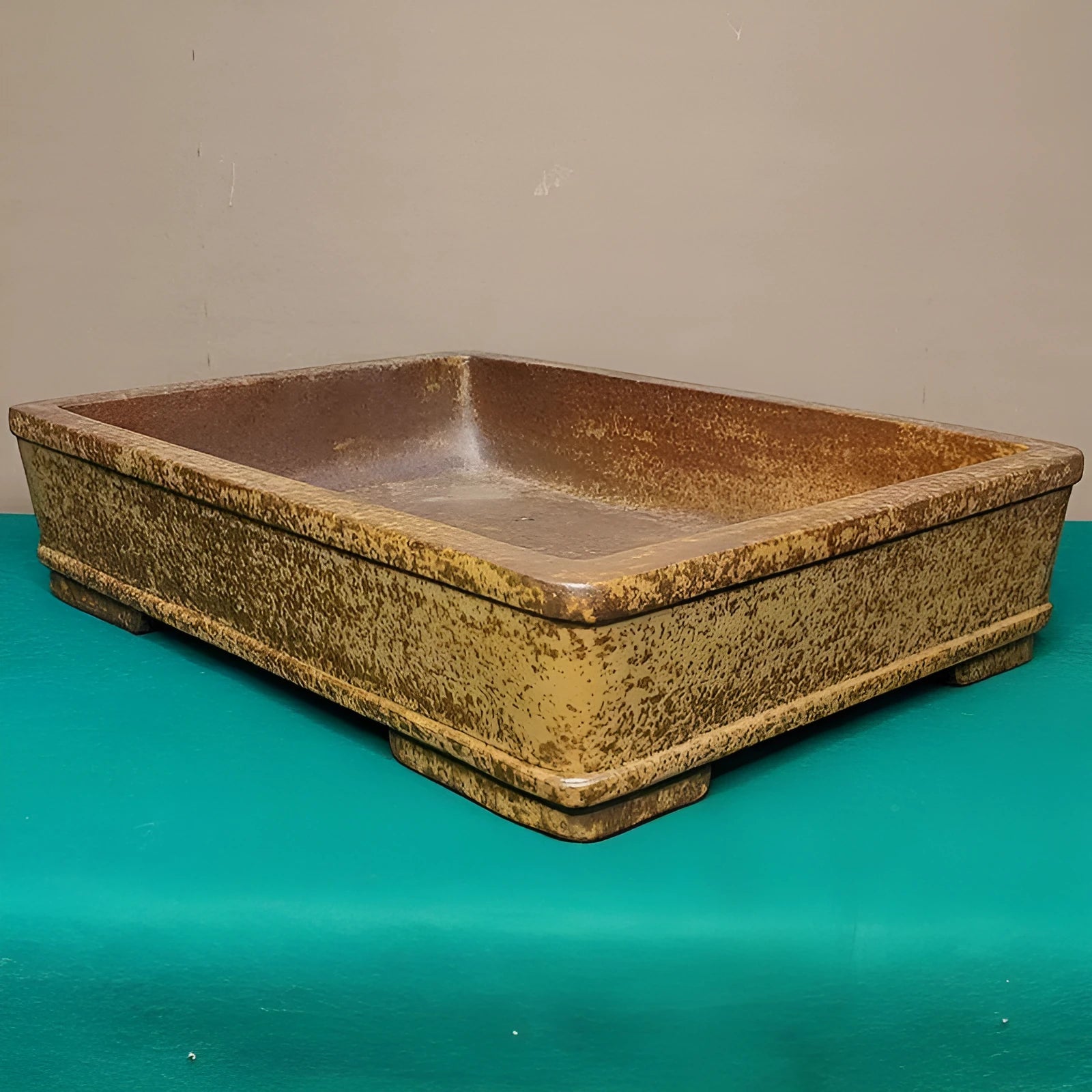 Straight shallow rectangular Yixing Zisha flowerpot in purple sand clay on a plain surface.