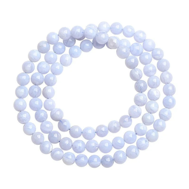 Blue agate bracelet with scattered multi-circle stripes and Ruyi design on wrist.