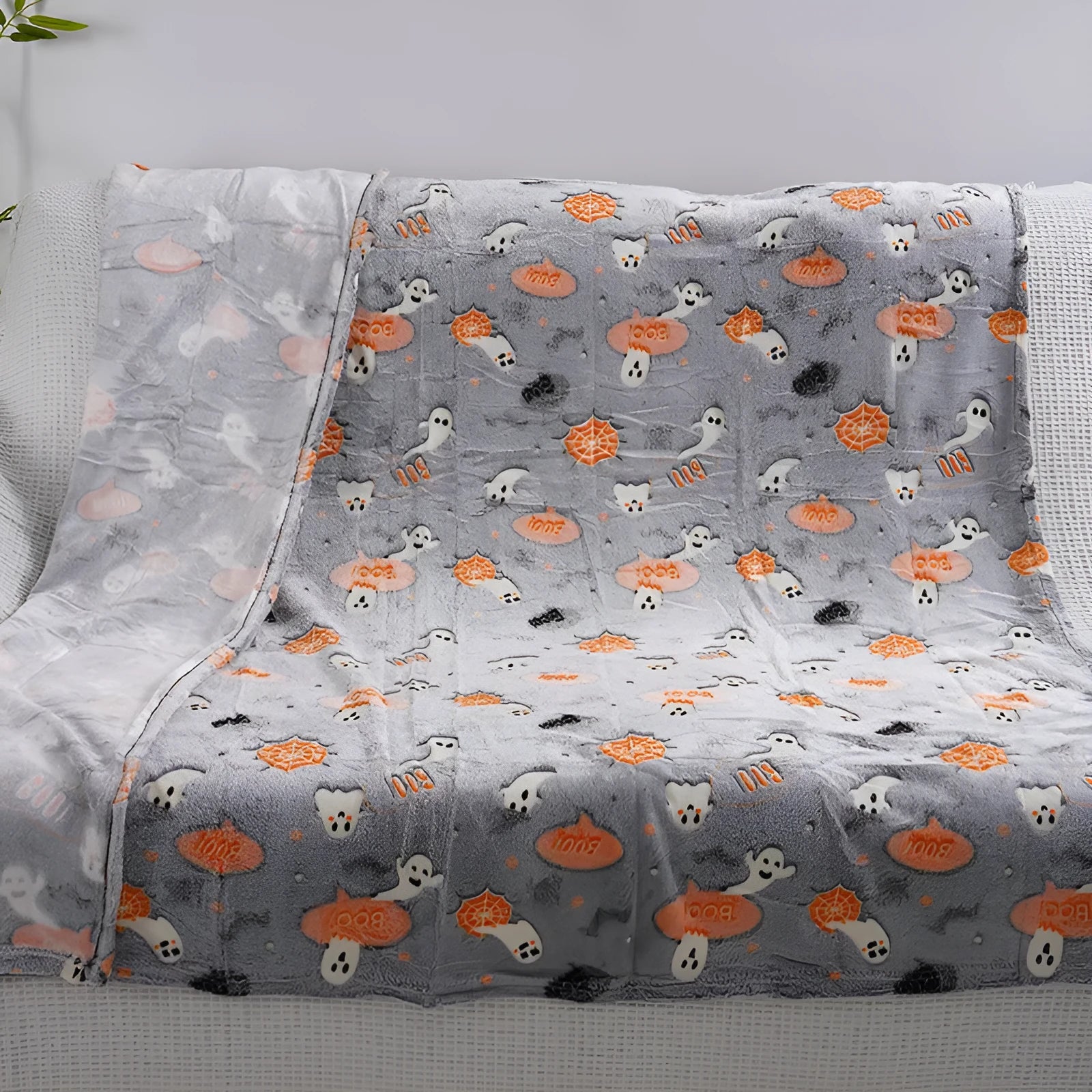 Cartoon print flannel blanket for children shown in two sizes on a bed.