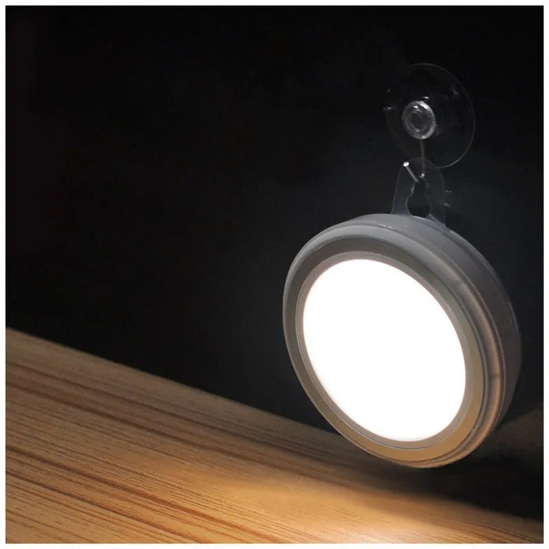 Circular white motion sensor LED light with 80mm diameter, shown mounted inside a wardrobe.