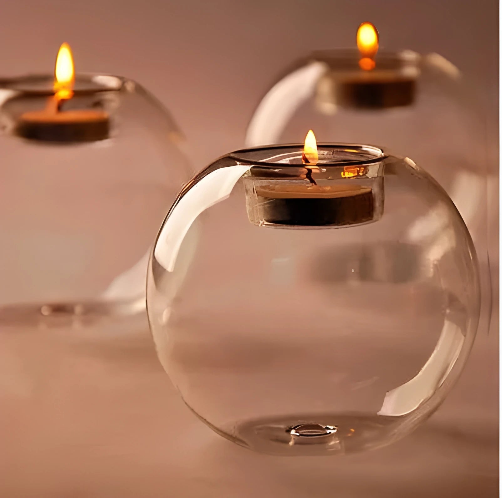 Handmade round hollow glass candle holder in clear glass on wooden surface