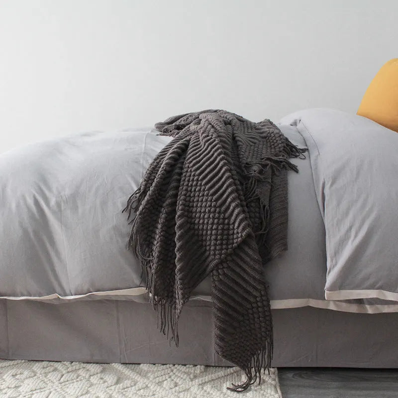 Small grey polyester nap blanket laid flat showing its size.