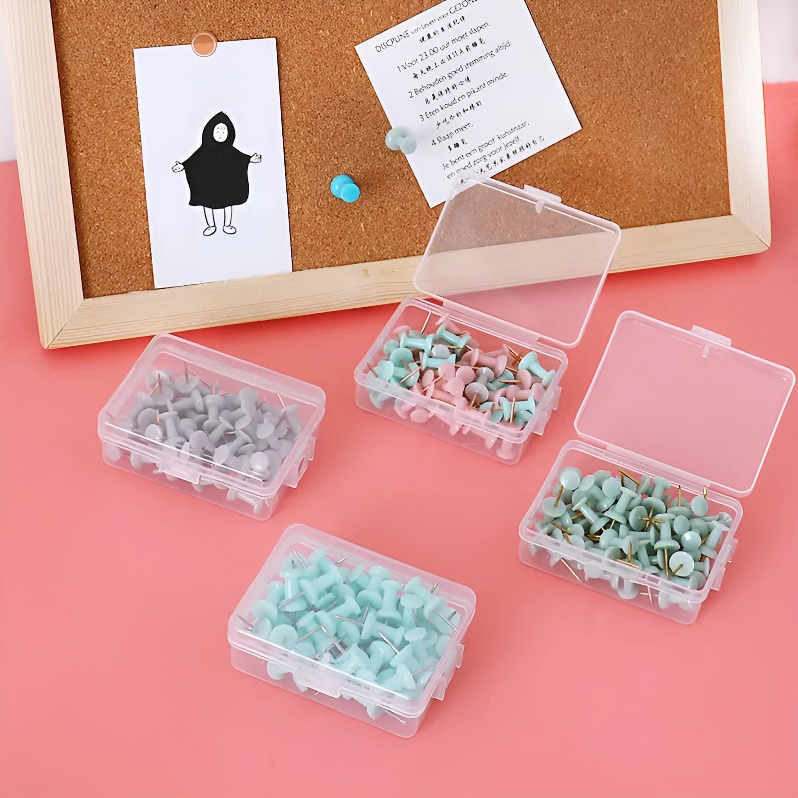 Morandi colour push pins in green, grey, and pink with three different head designs on cork board