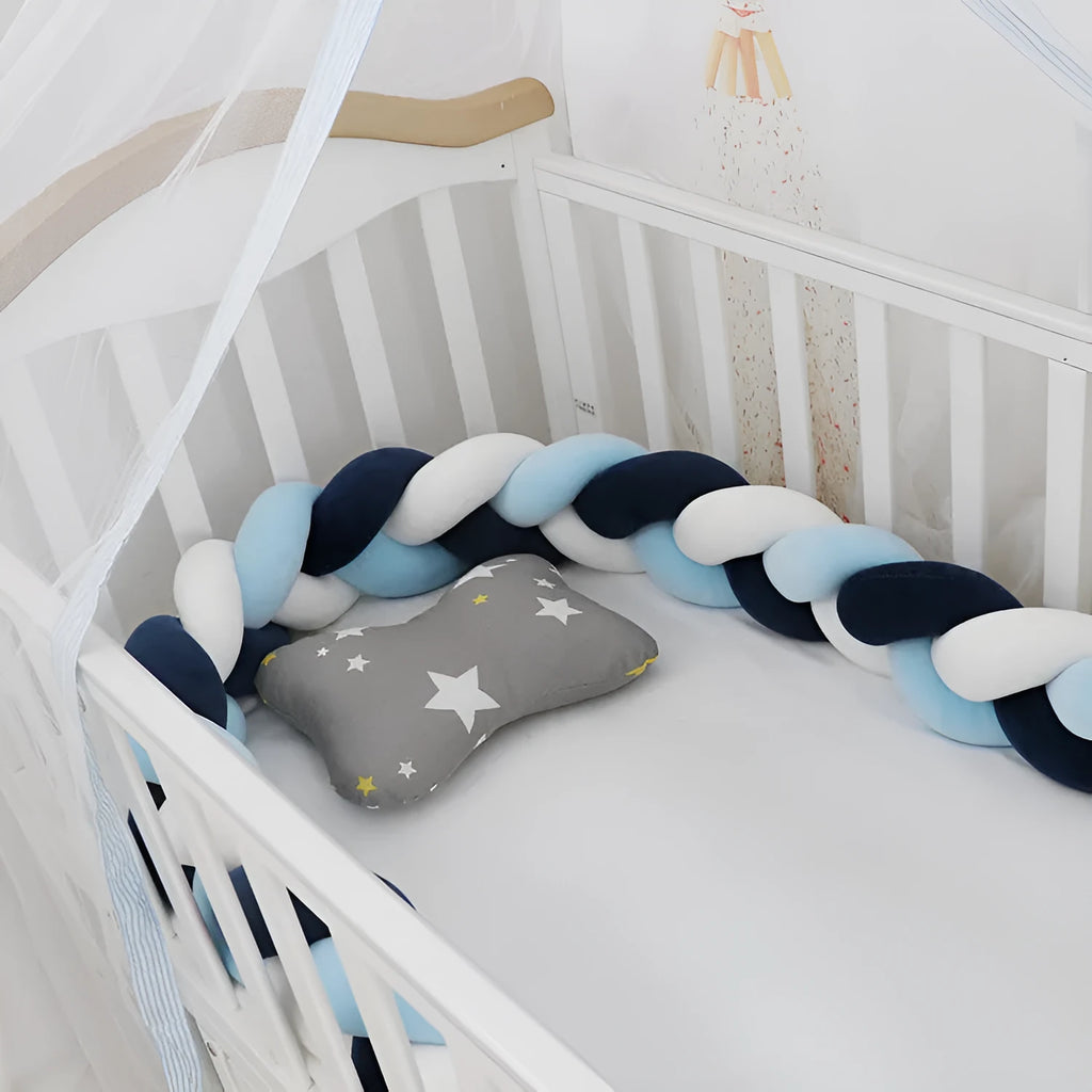 Braided knot pillow cushion bumper for infant crib in spandex velvet, shown in a light colour.
