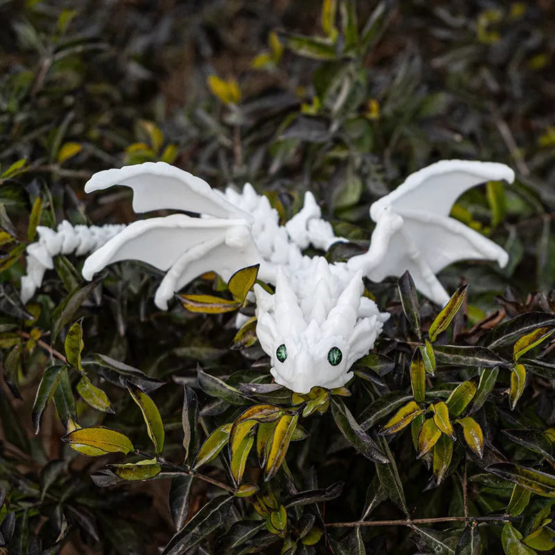3D printed red and gold flying dragon wings decoration toy on a white background.