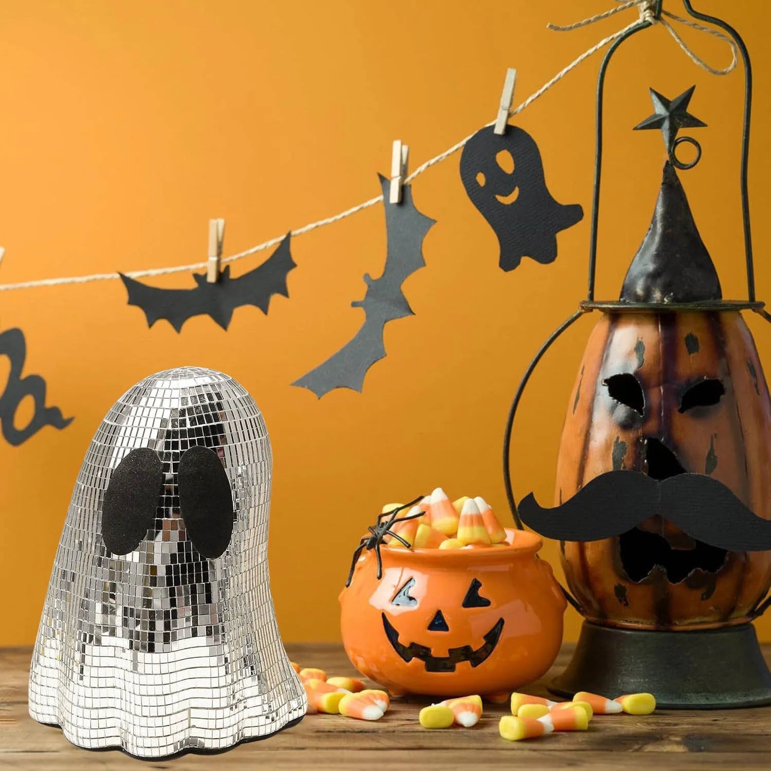 Silver glass Halloween ghost ornament with mosaic inlaid surface on a desktop.