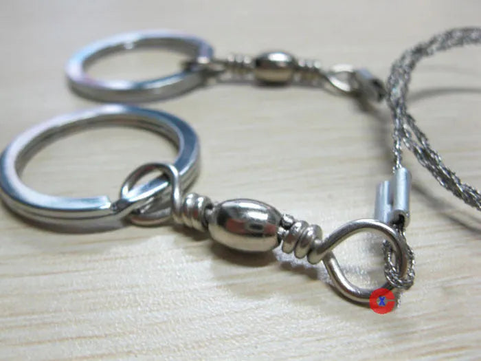 Stainless steel survival wire saw with thumb rings, extended to show its 70cm length.