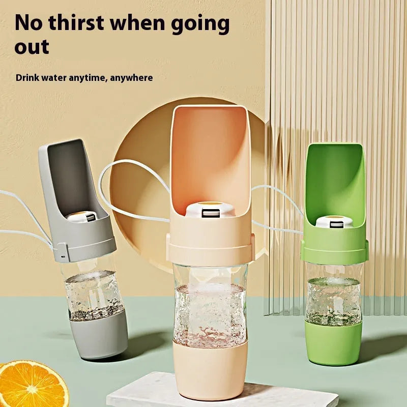 Green portable dog water bottle and feeder with attached lanyard, showing separate food and water compartments.