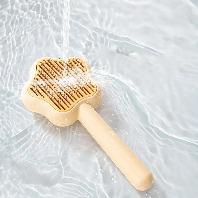 Self-cleaning stainless steel cat comb with green handle, showing 4-row needle design