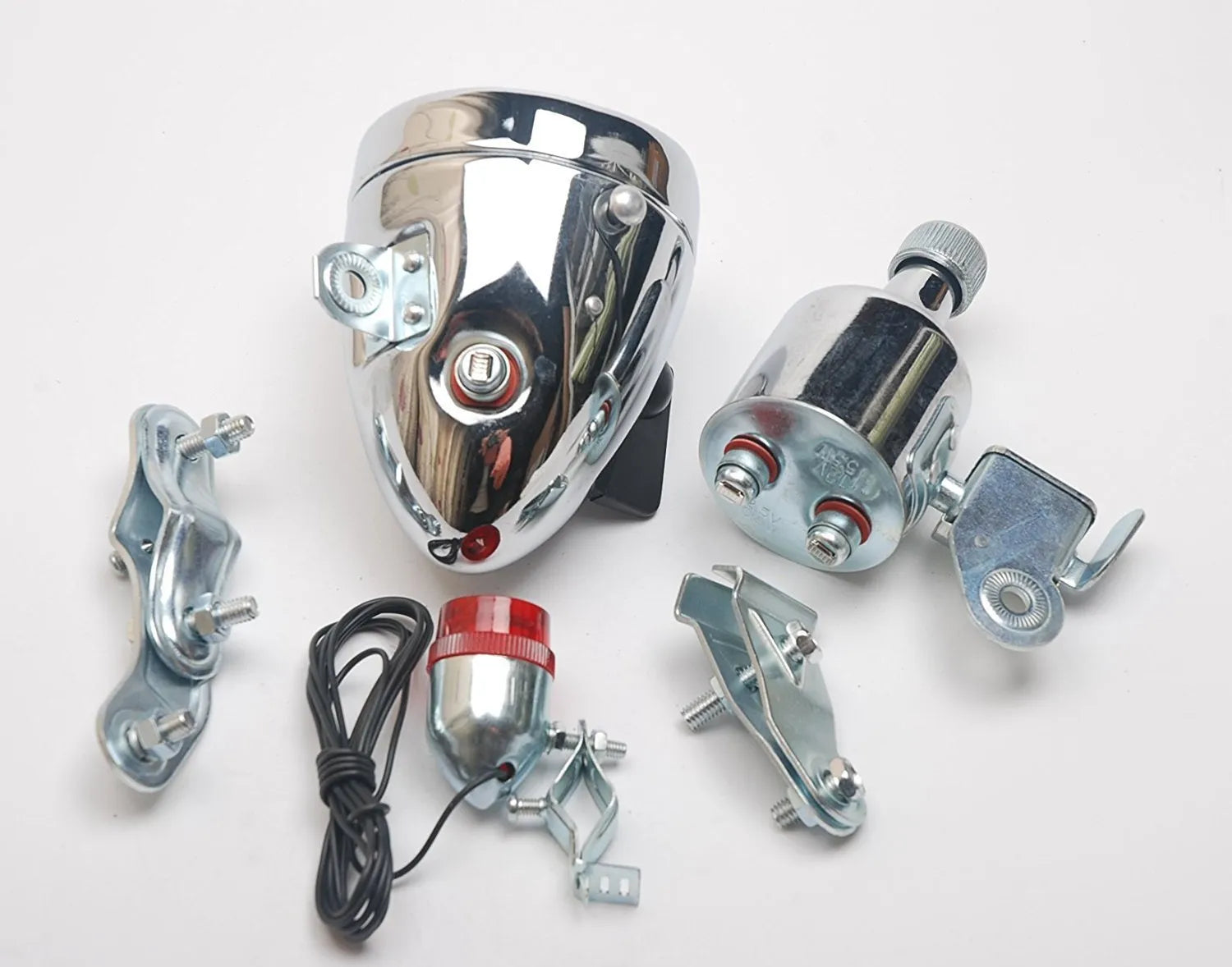 Silver bicycle dynamo generator light kit mounted on a bike fork, with wires for headlight and tail light connections.