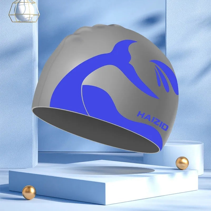 Silicone swimming cap with whale tail pattern and moulded ear protectors in various colours.