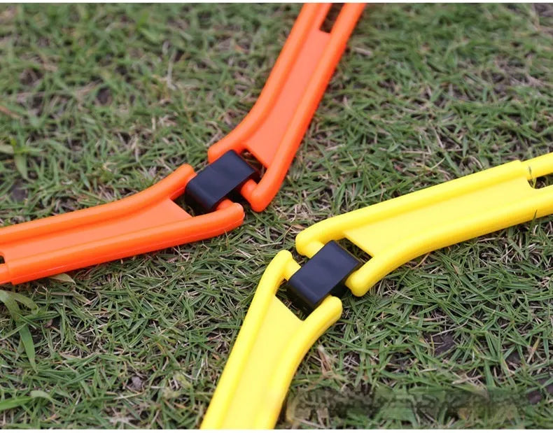 Set of six foldable yellow green and orange hexagon football agility training rings on grass