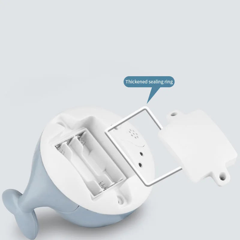 Whale-shaped baby bath toy with automatic water spray and colourful lights floating in water.