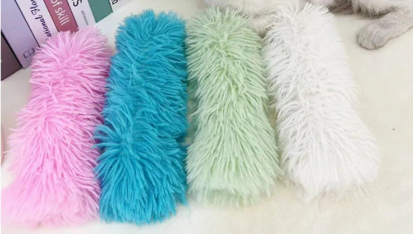 Blue, green, pink, and white plush cat toy pillow measuring 27 by 10 centimetres.