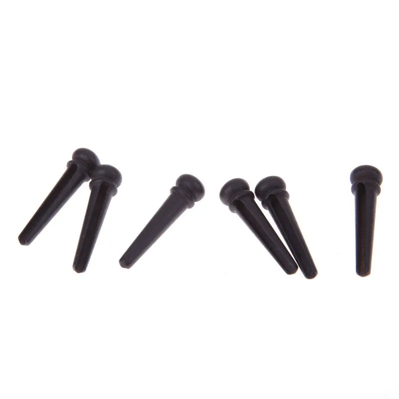 Six solid ebony guitar string nails with matt black finish for folk acoustic guitars.