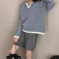 Woman wearing a loose red and blue striped cashmere pullover sweater with long sleeves.